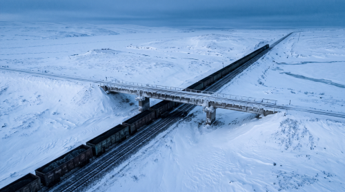 Firefly_Gemini-Flash_A-wide-angle-nadir-perspective-of-a-black-coal-railway-cutting-through-a-pristine-bl-820078.png